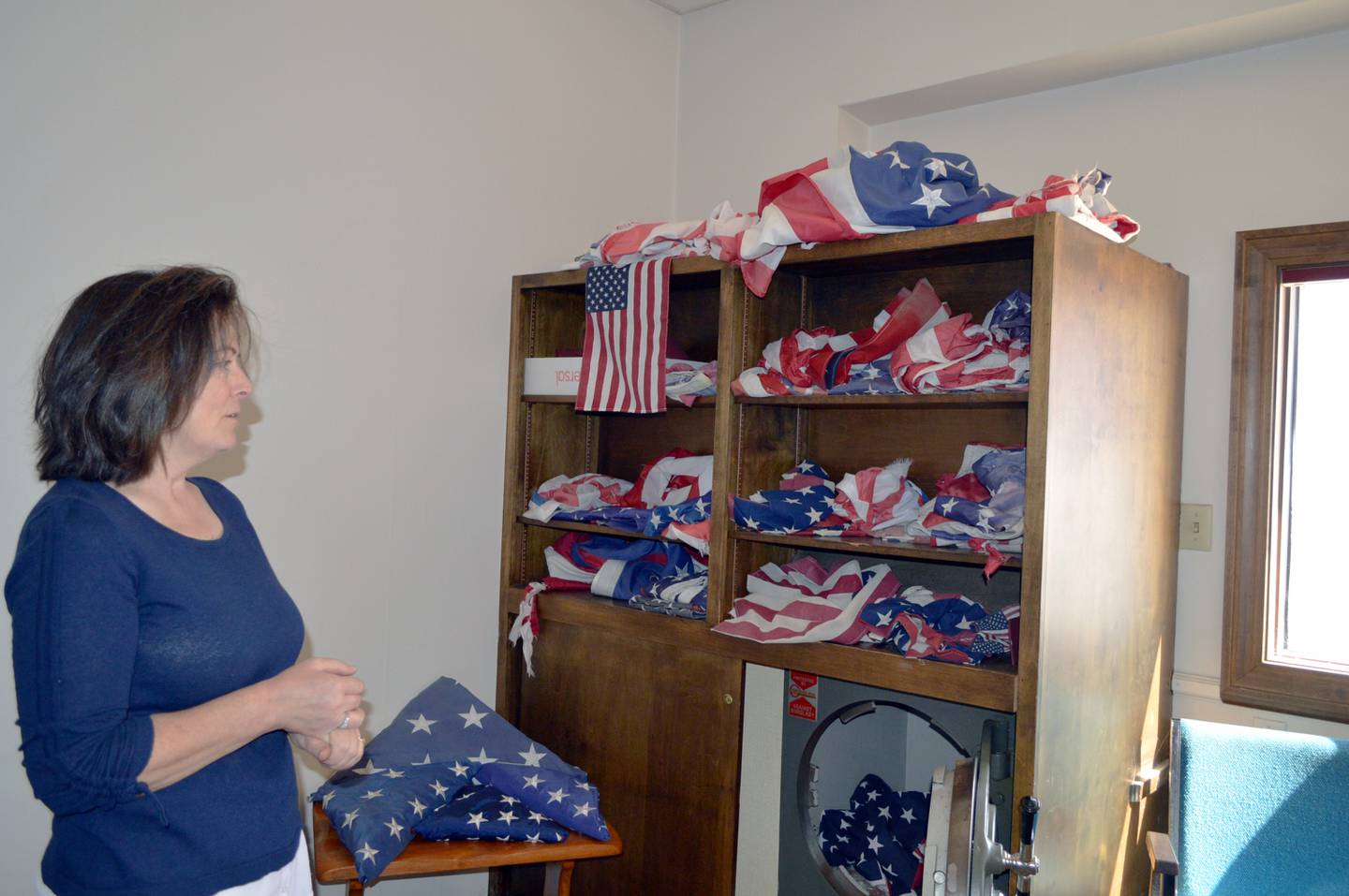 Polo's Patrick Fegan American Legion Post No. 83 Past Commander Cynthia Reynolds on Saturday, Sept. 28, 2024, looks at the American flags that have been dropped off at 101 W. Mason St., Polo, for proper disposal. The flags that aren't cotton will be given to local funeral homes to be cremated with veterans as part of the Legion's new Farewell Flags program.