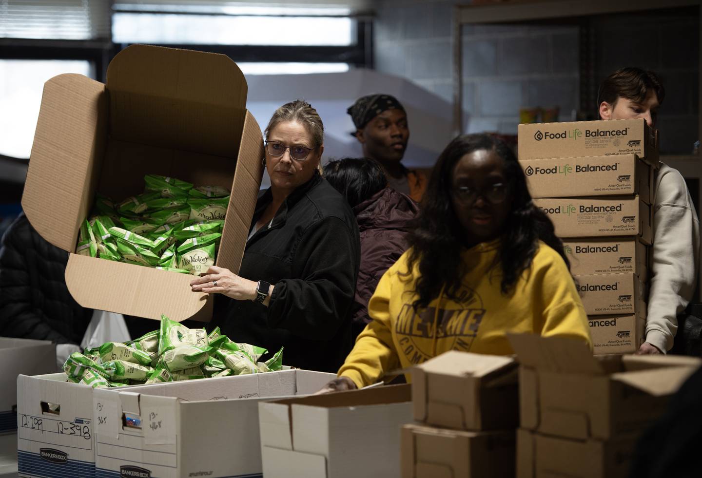Christine Porter, Kankakee School District 111 Special Education, Hearing Impaired, left, empties a box of potato chips during a donation drive by Convoy of Hope at Lincoln Cultural Center in Kankakee on Thursday, March 12, 2026.