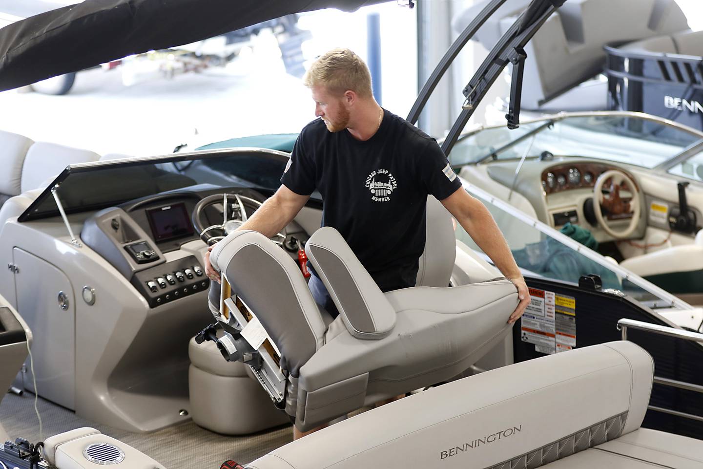 Mechanic Colin Wegner moves a seat a replaces the seat bases on a pontoon boat at Munson Marine, 3112 W. Lincoln Road, in McHenry, on Tuesday, Sept. 20, 2022. Munson Marine has brought the marina back to life after purchasing the derelict marina about two years ago.