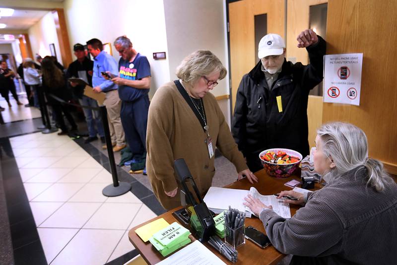 Amin Karim (center), a Democrat candidate for McHenry County treasurer, asks a filing question to McHenry Deputy County Clerk Debra Nieto (left) and clerk employee Melissa Massey, (seated) on the first day of filling for the 2026 Spring Primary Elections on Monday, Oct. 27, 2025, at the McHenry County Clerk's office in Woodstock. Karim was the first candidate in line to file.