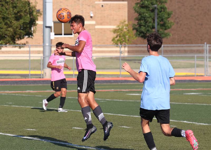 A DeKalb player heads the ball in front of a Sycamore player Monday, July 14, 2025, during a summer boys soccer friendly at DeKalb High School.