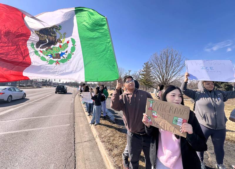DeKalb High School senior Kevin Mejia, (left) 18, and junior Ailany Padilla, 17, protest with classmates Tuesday, Feb. 10, 2026, on Sycamore Road in front of Hopkins Park in DeKalb. The students walked out of school Tuesday to protest against ICE involved violence and arrests.