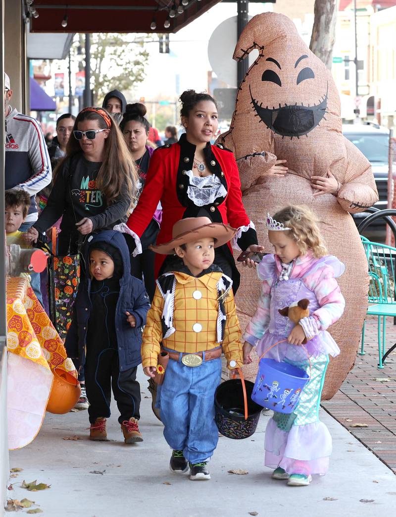 Trick-or-treaters head down the sidewalk on Lincoln Highway in downtown DeKalb Thursday, Oct. 27, 2022, during the Spooktacular trick-or-treating event hosted by the DeKalb Chamber of Commerce.