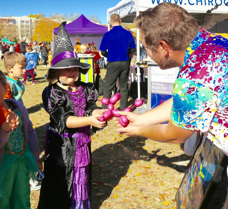 Maybellene Craig gets a poodle made by balloon artist Jonathan Sass at Batavia Bat Fest on Saturday, Oct. 26, 2024.