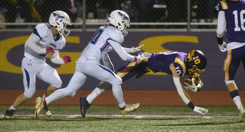 Wauconda's Chase Groelle (10) stretches for extra yardage under Lakes' defensive pressure during Friday’s football game in Wauconda.