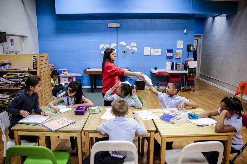 Reyna Hernandez helps children with their homework April 15 during the Kidz Zone after school-program at the Smith Family YMCA in Joliet.