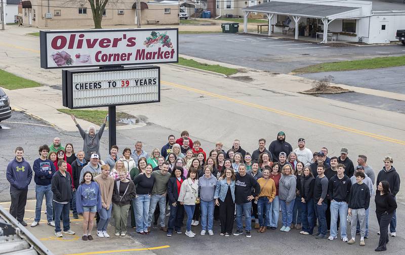 Former employees gather at the sign Saturday, April 4, 2026, for one last photo of Oliver’s Corner Market in Dixon. After 39 years, store owner Tim and Patty Oliver called it a career and retired.