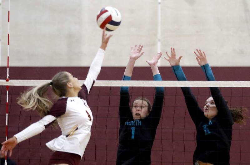Richmond-Burton's Daniella Hopp (right)l\ hits the ball over the block of Woodstock North's Tayler Menzel (center) and Avari Howard (right) Schefke during a Kishwaukee River Conference volleyball match on Wednesday, Oct. 15, 2025, at the Richmond-Burton High School in Richmond.