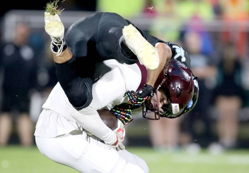 Marengo’s Parker Mandelky, bottom, gathers a reception as he is hit by Woodstock North’s Adan Castaneda in varsity football at Rod Poppe Field on the campus of Marengo High School in Marengo on Friday, Sept. 12, 2025.