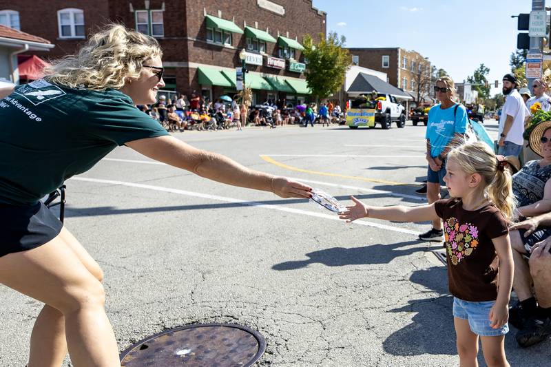 Scarlett Humphries receives a pair of sunglasses from a parade participant during the Grundy County Corn Festival Parade in Downtown Morris on Sept. 28, 2025.