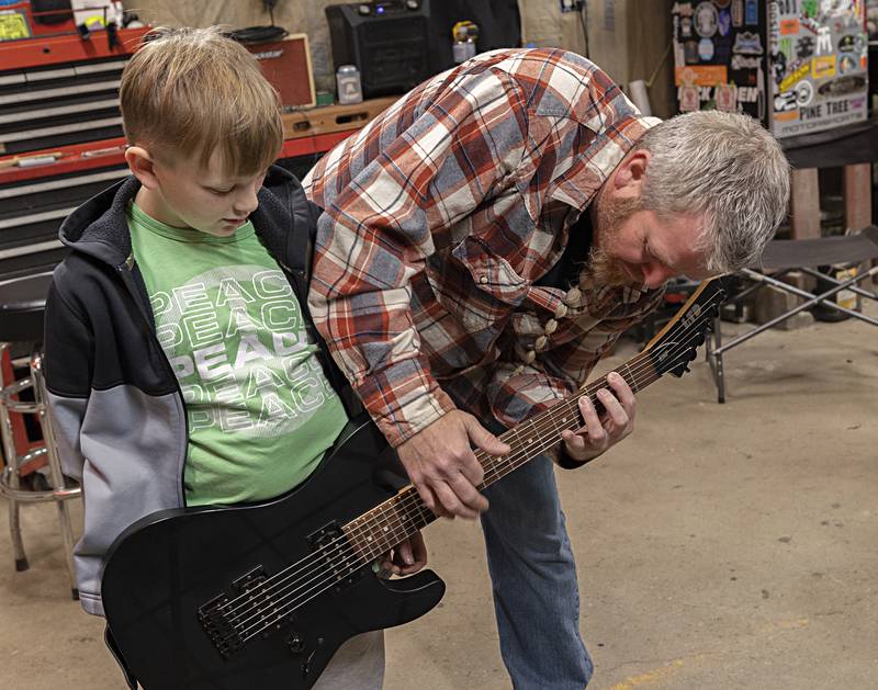 Jason Stephens tunes Kris Riggen’s new guitar Thursday, Dec. 7, 2023. The present was a surprise to the future rock star.