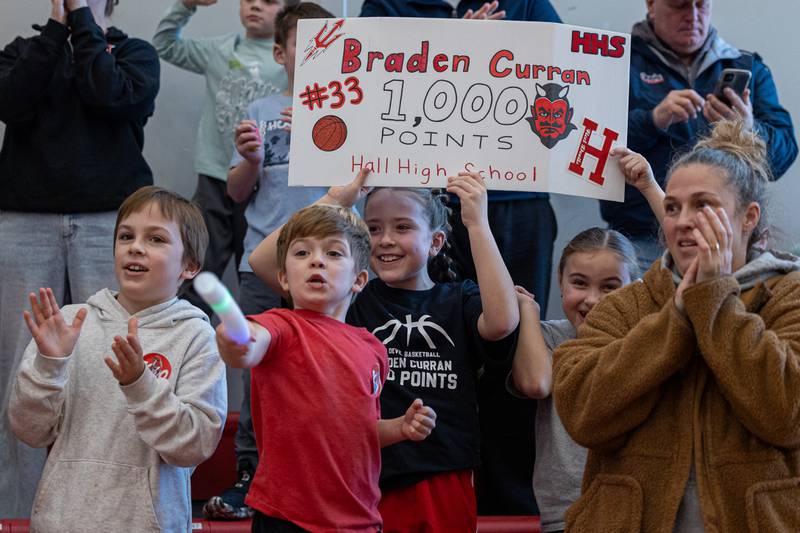Addison Fusinetti holds sign honoring Braden Curran (33) of Hall scoring 1,000 career points on Saturday, January 31, 2026 at Hall High School in Spring Valley.