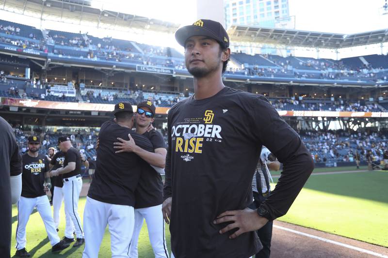 San Diego Padres' Yu Darvish looks on as teammates celebrate following a baseball game after clinching a wild-card playoff spot (AP Photo/Derrick Tuskan)