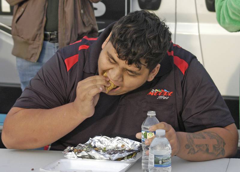 Xavier Melendez representing Moore Tires in RF competes in the taco eating contest. The Taco Throwdown Events sponsored by Rock Falls Tourism Event at RB&W District September 27th, 2024.