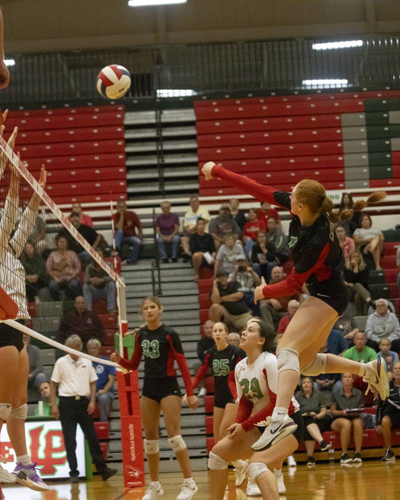 Addison Duttlinger spikes the ball over the hands of two Sycamore blockers to win the point during the varsity game on September 14, 2023.