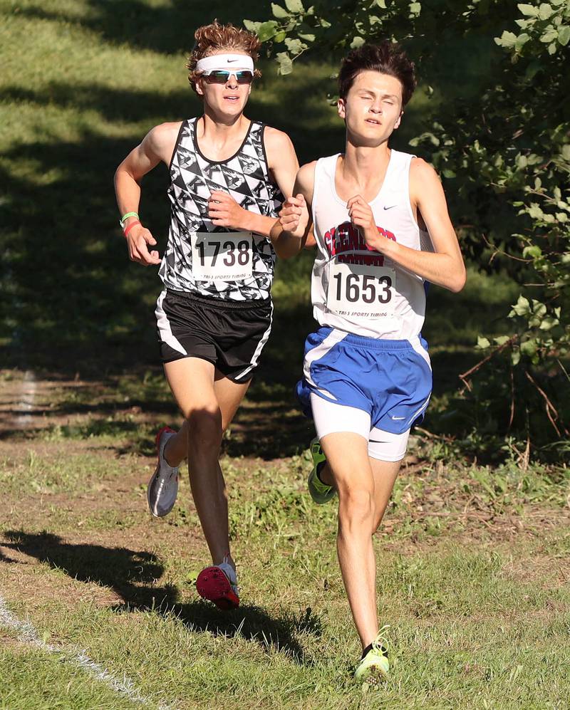 Kaneland's Evan Nosek heads down a hill just behind Glenbard South's Jaden Frederick Tuesday, Aug. 30, 2022, during the Sycamore Cross Country Invitational at Kishwaukee College in Malta.