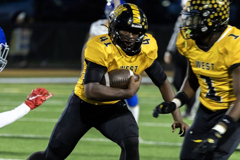 Joliet West's Gregory Lee picks-up yardage during a varsity football game against Joliet Central at Joliet West on Oct. 24, 2025.