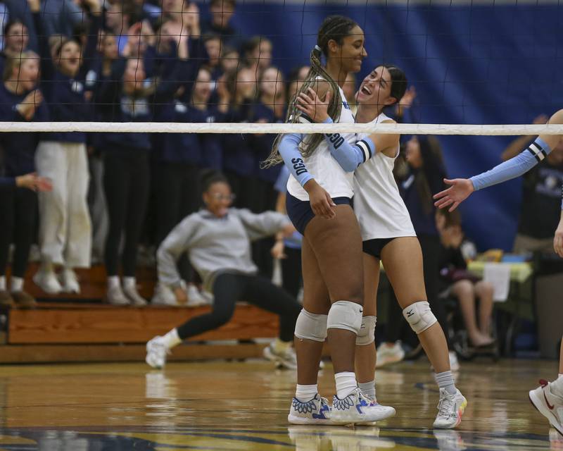 Downers Grove South celebrates a point while their student section cheers in the background during Class 4A Lyons Sectional Semifinal volleyball match between Downers Grove South at Downers Grove North. Nov 4, 2025 in La Grange.