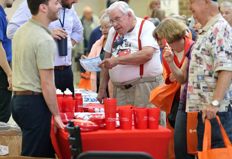 William Stewart, (middle) from Sandwich, asks a question at the Walgreens booth during a senior health fair Wednesday, July 12, 2023, at DeKalb High School. The event was hosted by local state legislators.