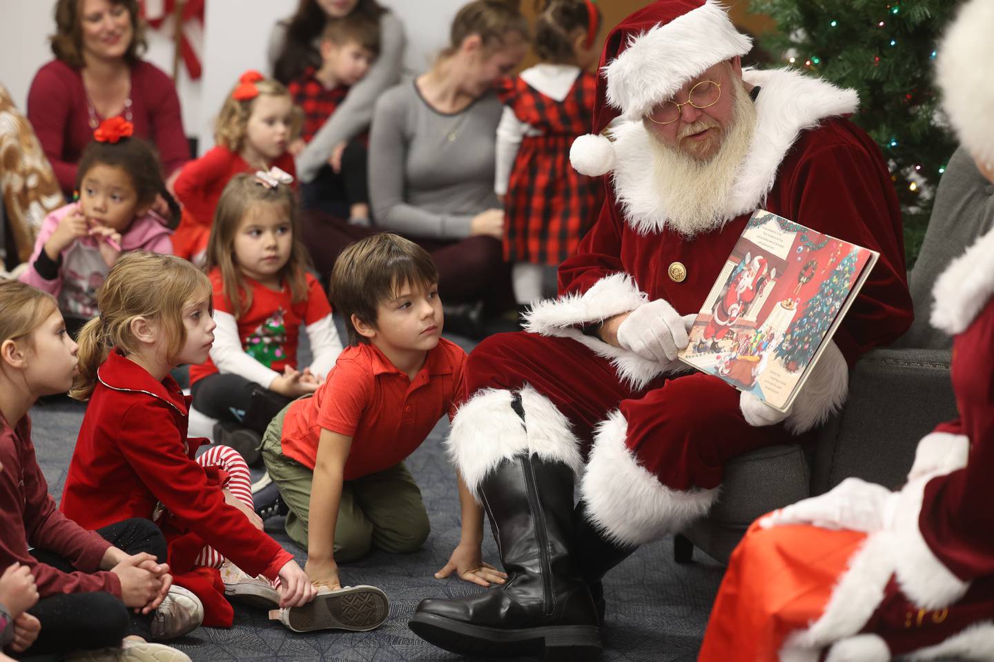 Jack Dell, 4, leans in as Santa reads a story to the children at the Shorewood-Troy Public Library.