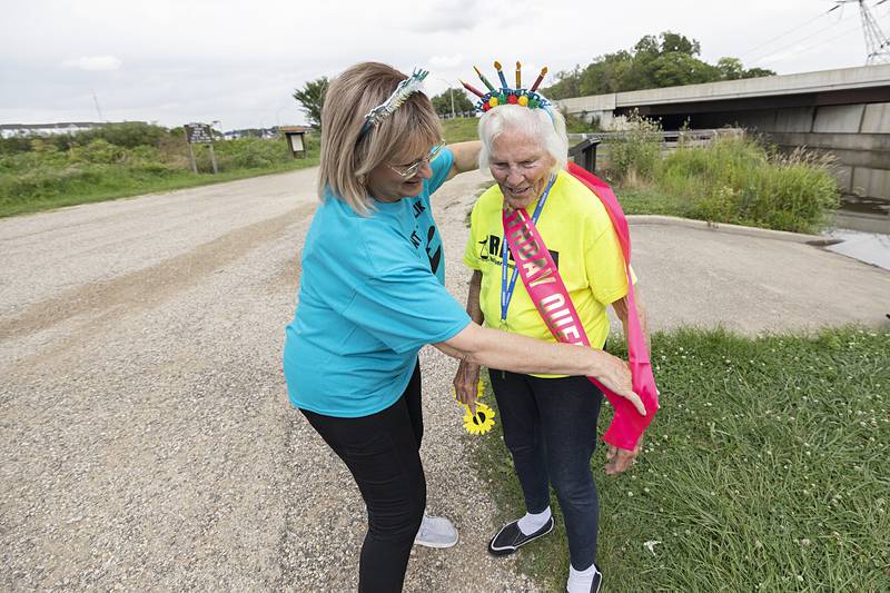 Teri Jahn sashes Nancy Gates as the “Birthday Queen” on Wednesday, July 24, 2024, before the Yak-Yak Sisters head out on the canal for their weekly float.