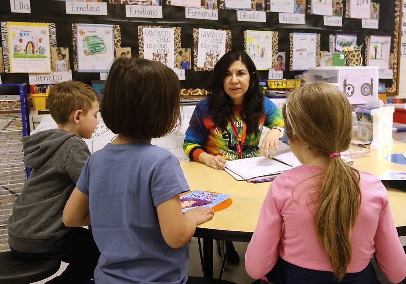 Kindergarten teacher Janet Moritz works with students on their reading Thursday, April 20, 2023, at Verda Dierzen Early Learning Center in Woodstock.