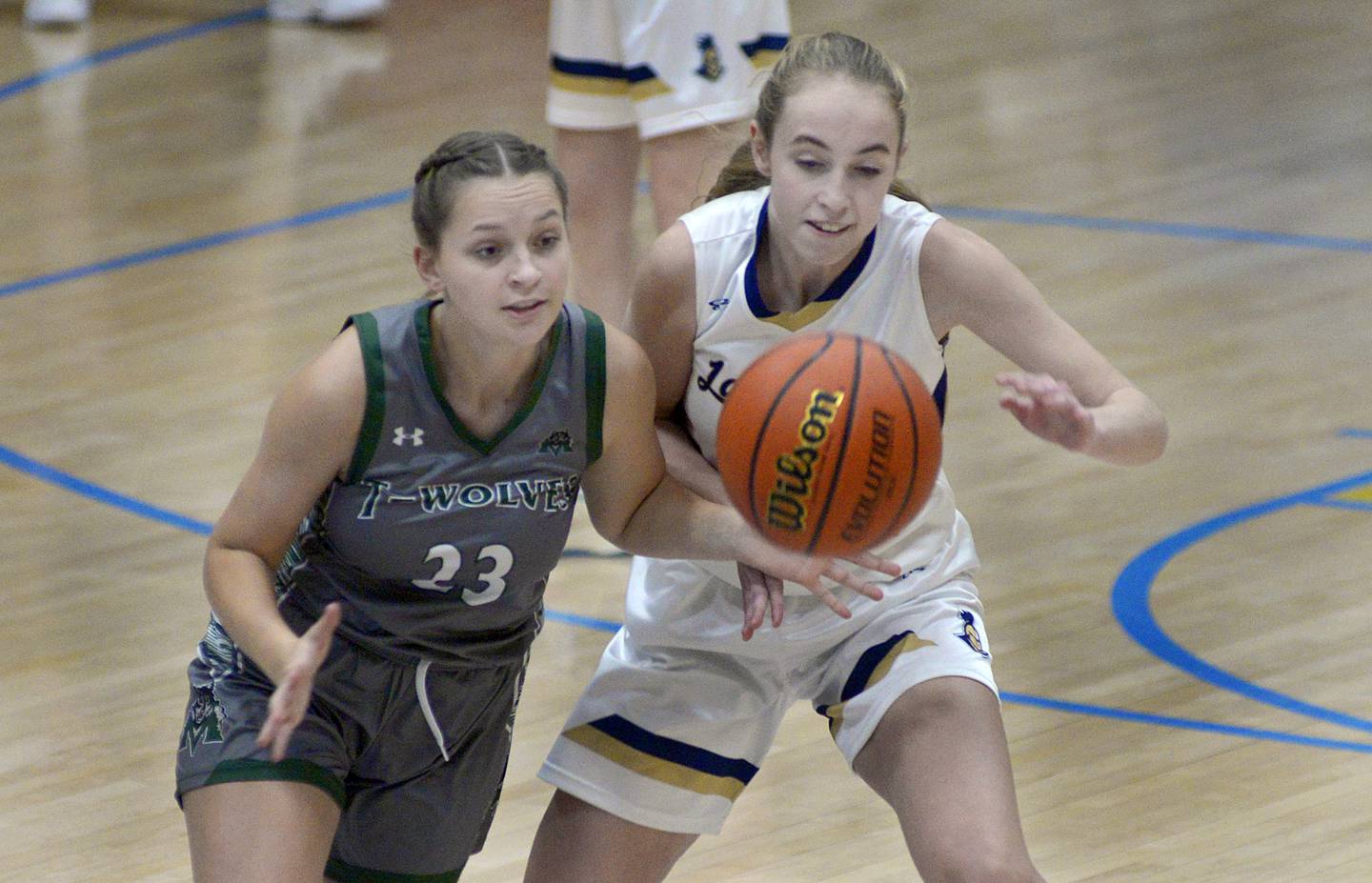 Marquette’s Lilly Craig and Midland’s Maddie Pyles battle for a loose ball early in Thursday's Tri-County Conference game at Bader Gym in Ottawa.