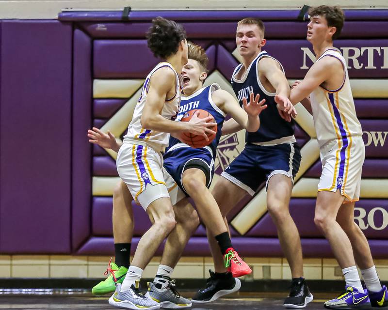 Downers Grove South's Daniel Sveiteris (25) draws a charge from Downers Grove North's Aidan Akkawi (24) during basketball game between Downers Grove South at Downers Grove North. Dec 16, 2023.