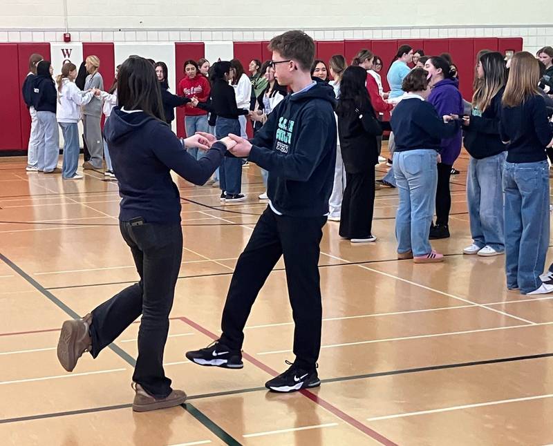 Just before departing Woodlands Academy March 21 after a two-week visit, students from Gymnasium Sacré Coeur Wien in Austria taught their sister Sacred Heart school students some basic steps of the Viennese Waltz during an all-school assembly.