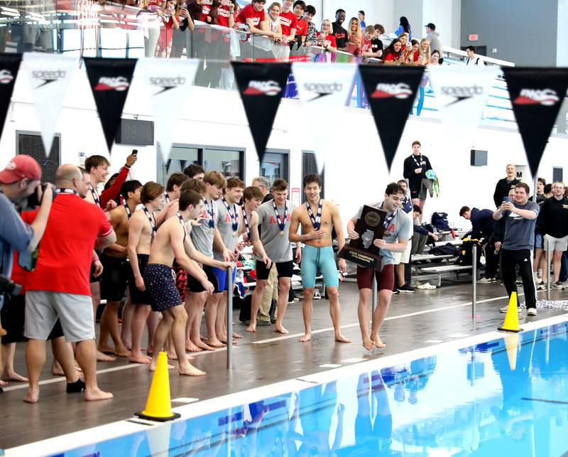 Hinsdale Central swimmers celebrate their first-place finish in the IHSA Boys State Championships by jumping in the pool on Saturday, March 1, 2025 at the FMC Natatorium in Westmont.
