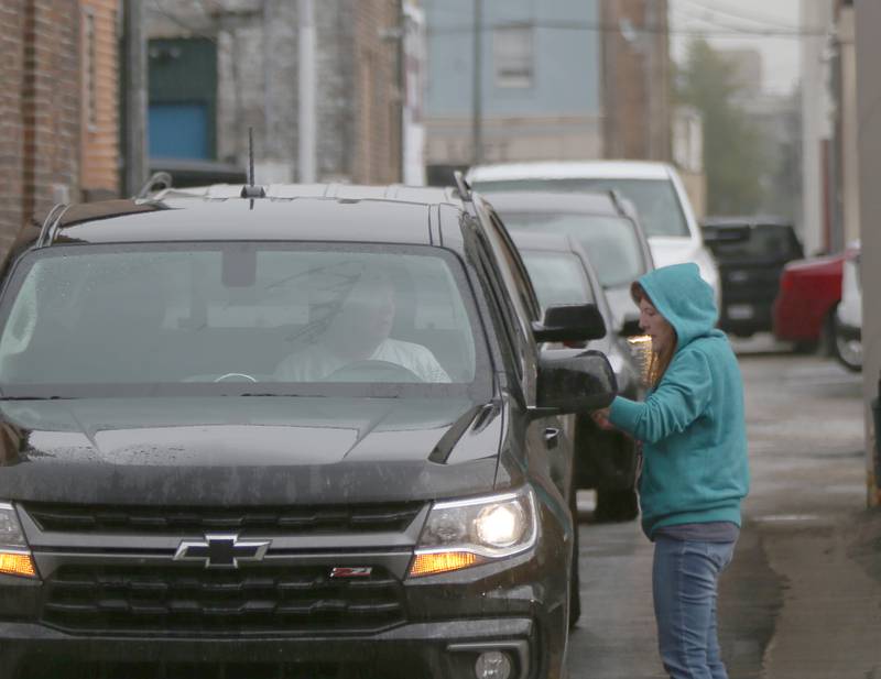 Mary Jo Credi, executive director of the Illinois Valley Food Pantry waits on a long line of cars during food distribution on Wednesday, Oct. 11, 2023 at the Illinois Valley Food Pantry in La Salle.