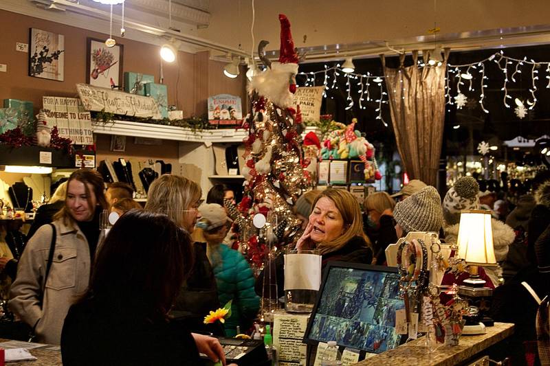 Christmas Walk patrons stop into downtown Oswego stores, such as The Marmalade Tree, on Friday, Dec. 3.