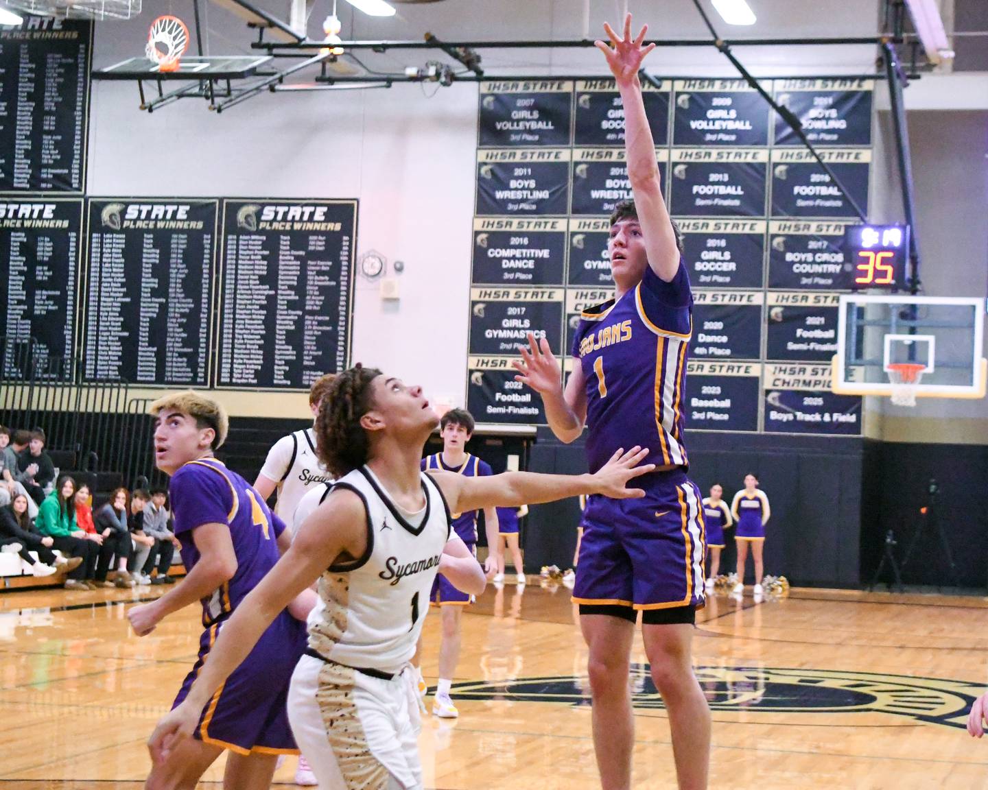 Mendota's Cole Tillman, right, makes a shot while being defended by Sycamore's Josiah Mitchell (1) during the game on Wednesday Dec. 17, 2025, held at Sycamore High School.