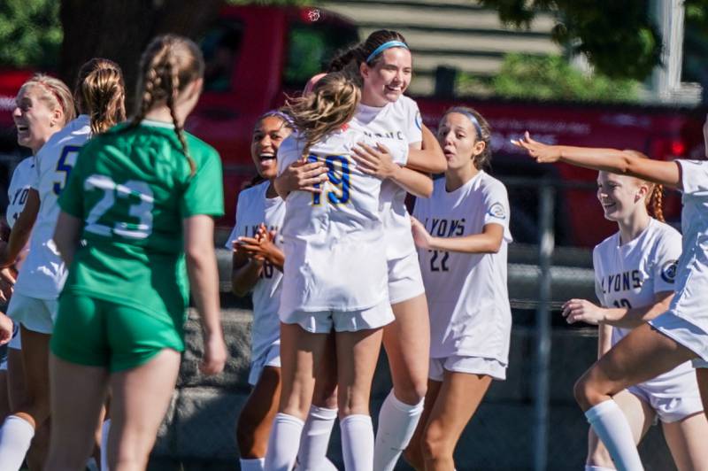 Lyons’ Caroline Mortonson (center) hugs Brennan Israel (19) after scoring a goal against York during a Class 3A Hinsdale Central Sectional girls soccer championship match at Hinsdale Central High School on Saturday, May 25, 2024.