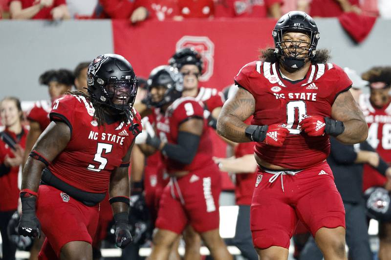 North Carolina State's Joshua Harris (0) and C.J. Clark (5) celebrate a sack against Connecticut during the second half of an NCAA college football game in Raleigh, N.C., Saturday, Sept. 24, 2022. (AP Photo/Karl B DeBlaker)