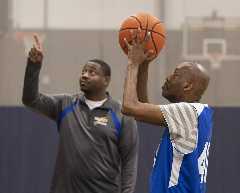 Coach Eli Townsend points the way for Tim Wednesday, Dec. 18, 2024, during Special Olympic basketball practice.