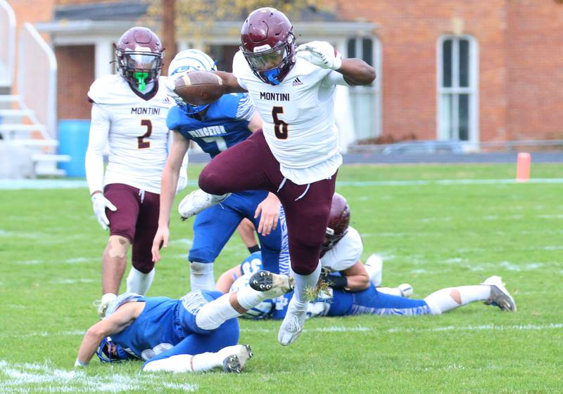 Montini Catholic's Jeremiah Peterson jumps over Princeton's Ace Christiansen to gain extra yards on a run in the first quarter during the Class 3A quarterfinal game on Saturday, Nov. 16, 2024 at Bryant Field in Princeton.
