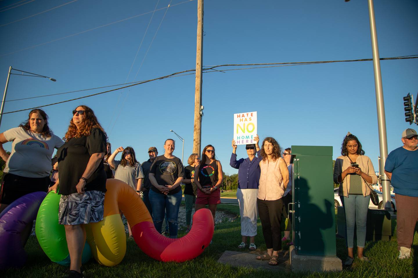 Attendees of the Pride Fire Hydrant Rally stand and hold signs at the northwest corner of Kirk Road and State Street/Rte. 38 in Geneva on Tuesday, Aug. 9, 2022.
