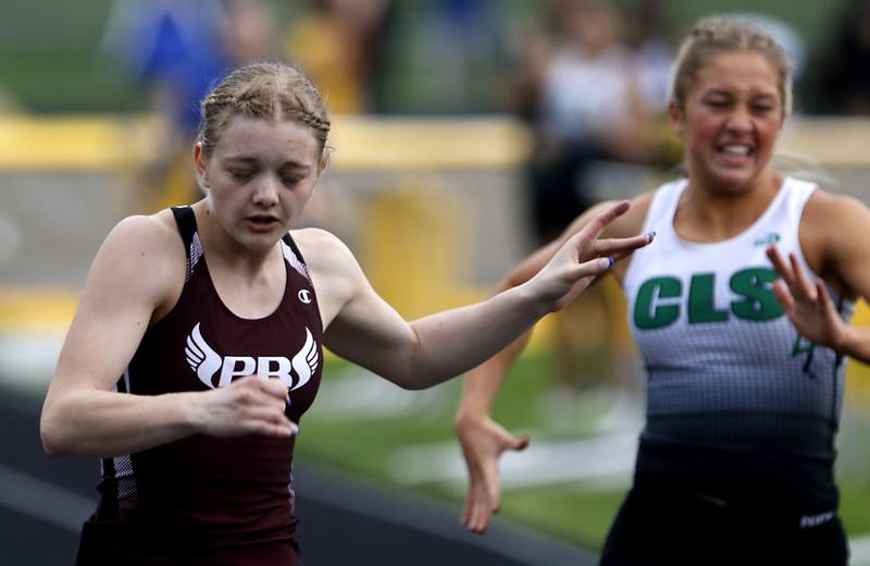 Prairie Ridge’s Katherine Jewell leans over the line to win the 100 meter dash on Thursday, May 2, 2024, during the Fox Valley Conference Girls Track and Field Meet at Jacobs High School in Algonquin.