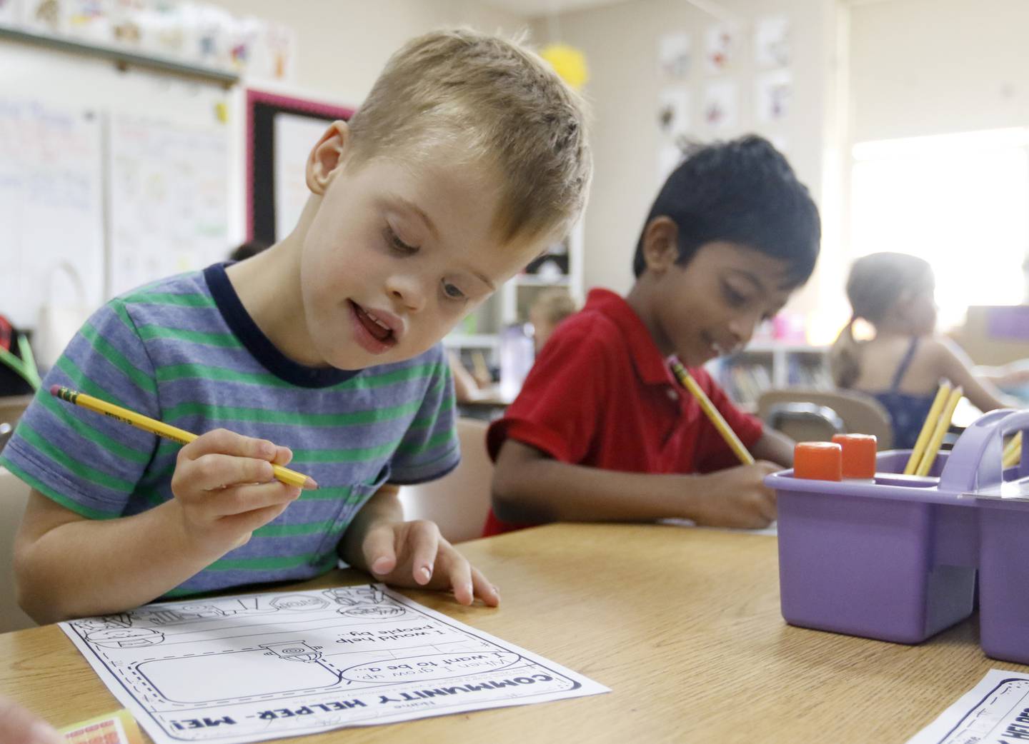 Cody Binger, a first grader with Down syndrome, works on a class assignment about community helpers on Wednesday, Sept. 14, 2022, at Leggee Elementary School in Huntley. Binger will appear in a national video aimed at raising awareness of Down syndrome, set to be shown in Times Square on Saturday, Sept. 17. The video will include 500 adults and children with Down syndrome.