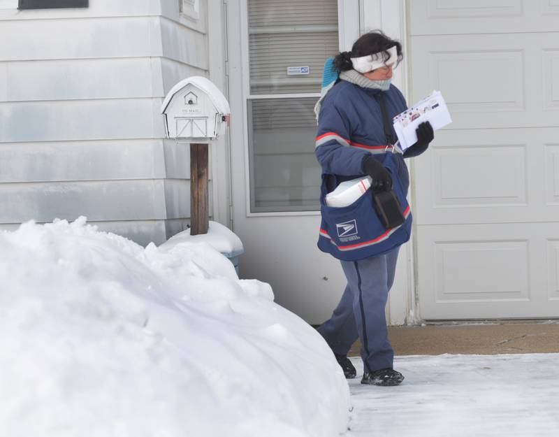 USPS postal worker Val Villarreal was busy delivering mail along Lincoln Street in Mt. Morris on Saturday, Jan. 13, 2024. She was forced to walk in the street for most of her route because portions of sidewalks were not shoveled.. Friday's winter storm dumped 10-12 inches of snow on the village with strong winds, more snow, and zub-zero temperatures forecasted into Sunday.