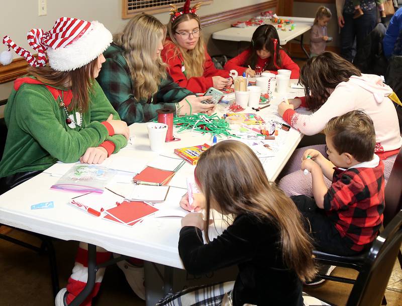 Volunteers help at a craft table at Breakfast with Santa in Elburn on Sunday, Dec. 4, 2022.