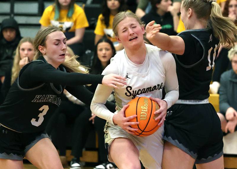 Sycamore's Lexi Carlsen goes to the basket between Kaneland's Alexis Schueler (left) and Berlyn Ruh during their game Wednesday, Feb. 7, 2024, at Sycamore High School.