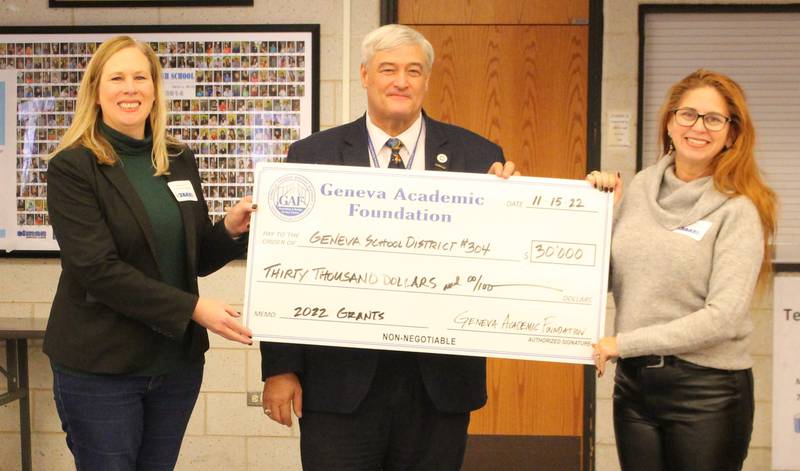 The Geneva Academic Foundation Vice President Bridget Wrobel-Greeley (left) and president Kimberly Luthin present (far right) present District 304 Superintendent Kent Mutchler a check for $30,000 at the annual leadership breakfast Tuesday.