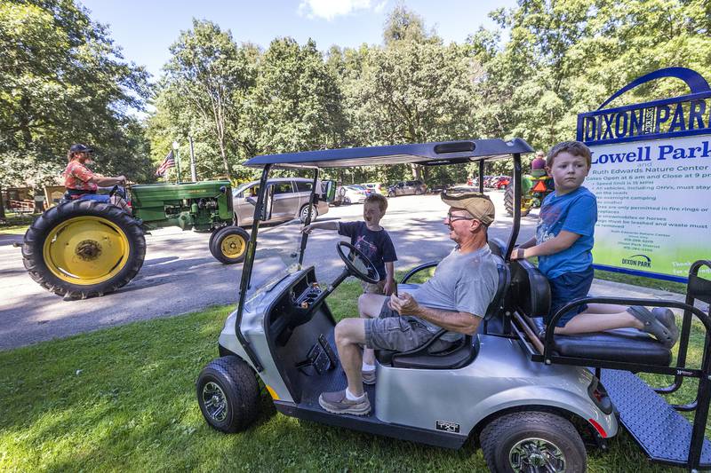 Dan Mahan brought in grandsons William Payne (left), 4, and Chandler Payne, 7, to watch the tractor ride Saturday, Aug. 31, 2024, in Lowell Park.