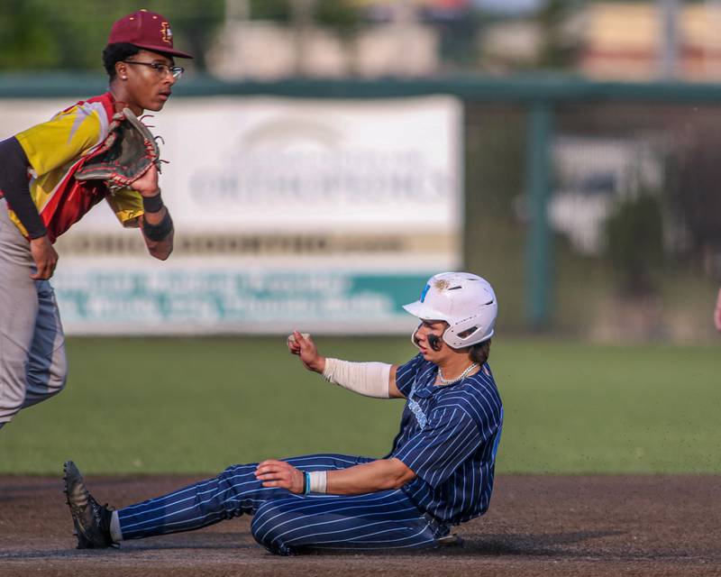 Nazareth's Jaden Fauske (21) slides into second base during Class 3A Crestwood Supersectional game between Lindblom at Nazareth.  June 5, 2023.