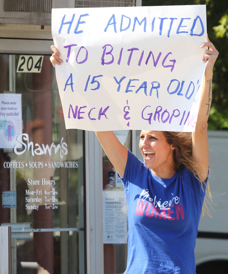 Sarah Slavenas, of Genoa, acknowledges a passing motorist who honked in support during a march in front of Shawn's Coffee Shop in Sycamore Friday. Protesters were picketing to inform the public of allegations that the owner, Shawn Thrower, committed misdemeanor battery against a 15-year-old employee. Thrower allegedly bit and inappropriately touched the employee.