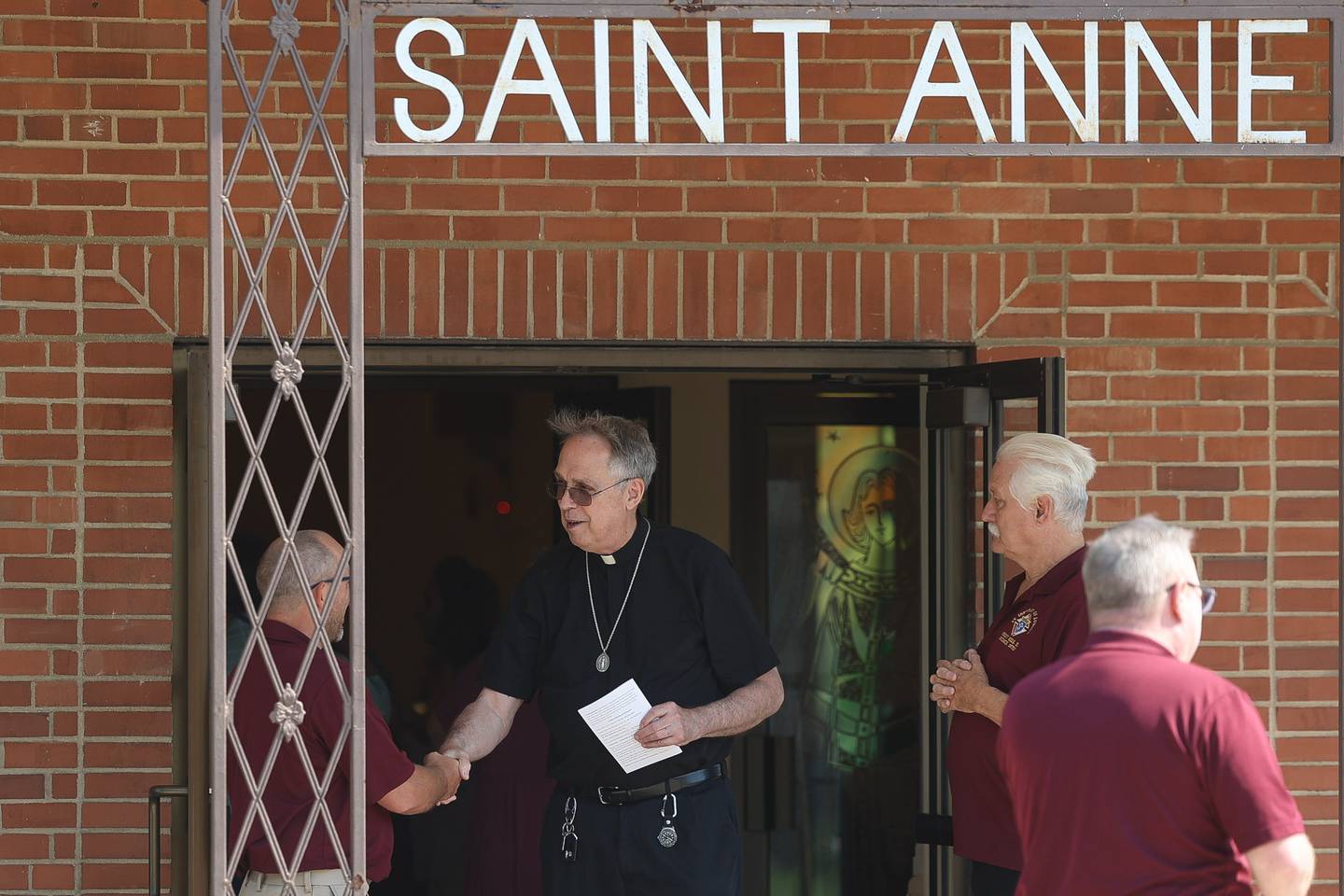 A priest greets parish members before the start of Saint Anne’s final mass on June 16, 2024 in Crest Hill.