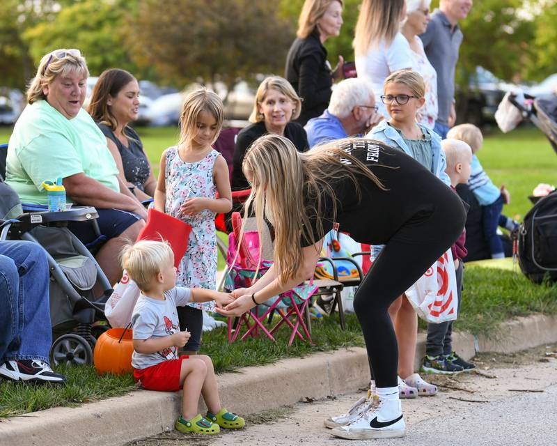 Yorkville High School volleyball player Aubrey Spchalski, freshman, lets Luke Karper, 2 years old, of Yorkville, pick out candy during the Yorkville homecoming parade held on Thursday, Sept. 28, 2023.