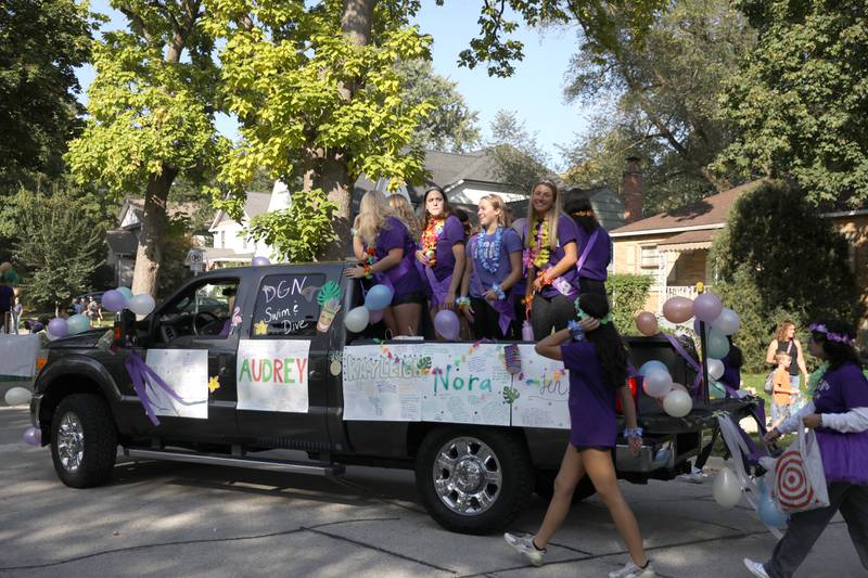 Members of the Downers Grove North girls swim and dive team ride on the back of a truck during the school’s annual homecoming parade on Friday, Sept. 29, 2023.